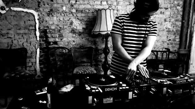 Eine schwarz weiß Aufnahme von DJ SID an seinen Turntables.