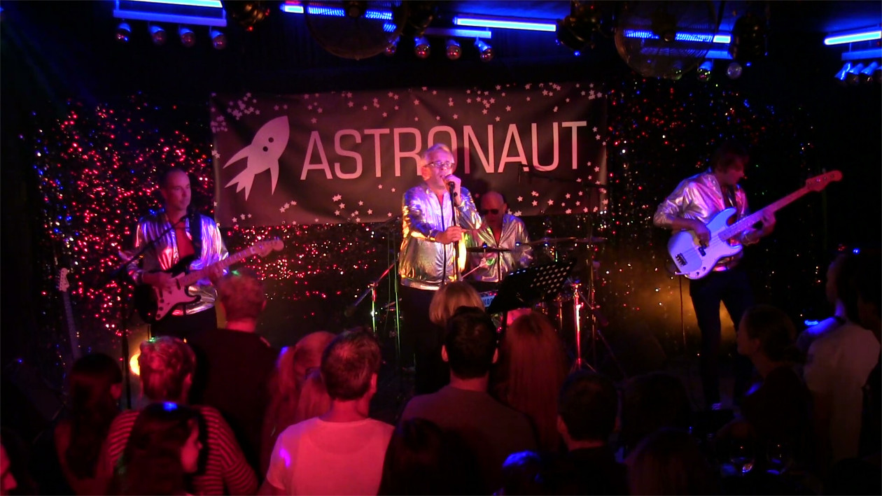 Die band Astronaut spielt auf einer Bühne, man sieht die vorderste Reihe Zuschauer.